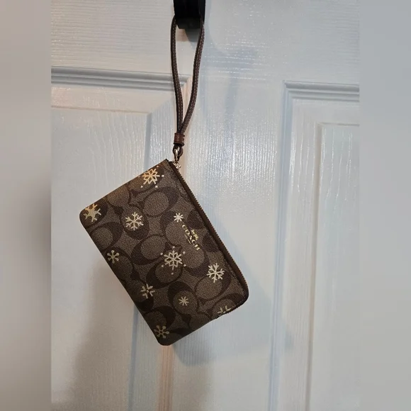 Celebrate the season with this stylish Coach wristlet wallet featuring a winter- - Picture 1 of 3